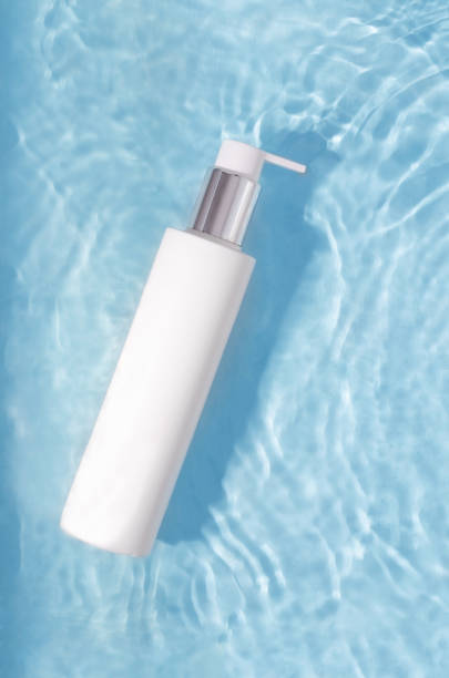 istock White bottle with cream in water on a blue background 1398525237