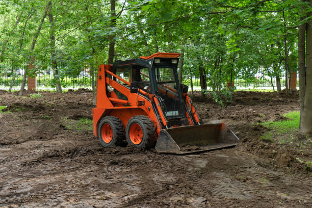 istock Skid steer loader or mini loader clearing site in public park moving soil and performing landscaping works for territory improvement. 1398541324