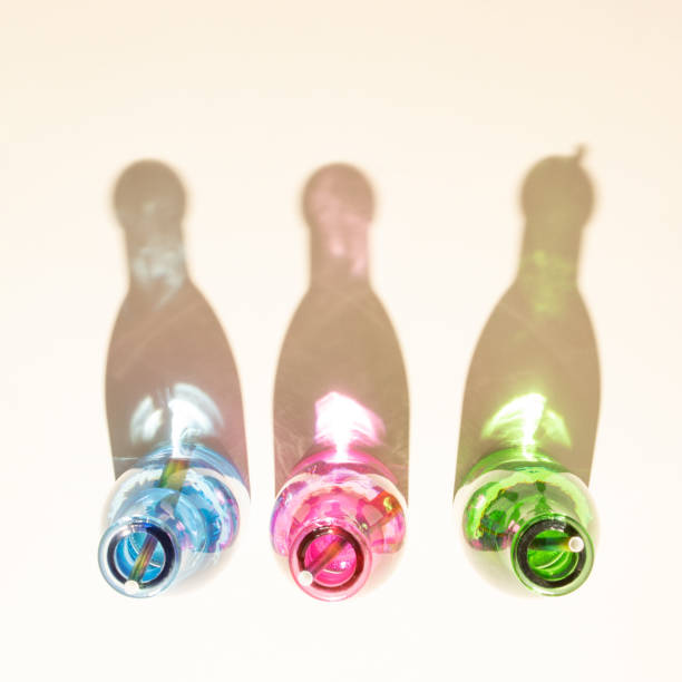 istock Colorful bottles with cold drinks on sandy background. Shadows with shiny colorized reflections. Aesthetic abstract design idea. Sunny beach day concept. 1398544145