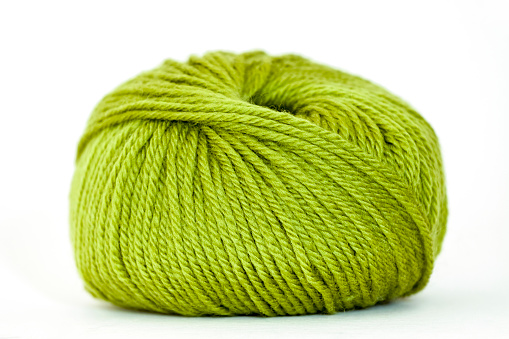 Merino wool green yarn, white background with copy space, horizontal composition
