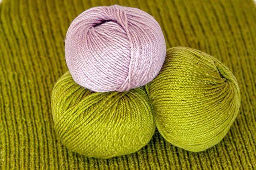Merino wool yarn, green and purple, background with copy space, horizontal composition
