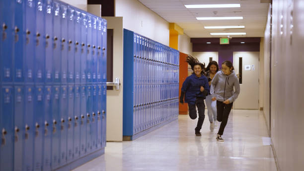 istock Three school kids running through school corridor 1398547012