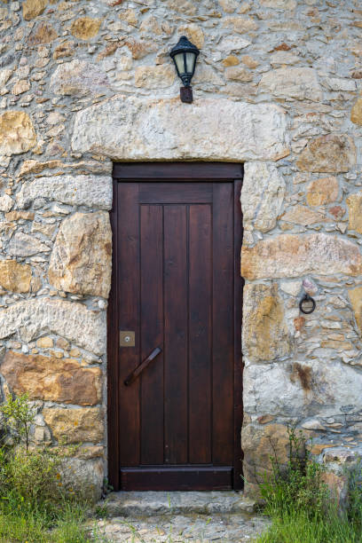 Ancient wooden door in stone wall.