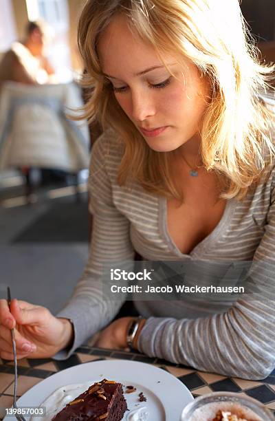 Foto de Jovem Mulher Comendo Bolo De Chocolate No Restaurante e mais fotos de stock de Restaurante