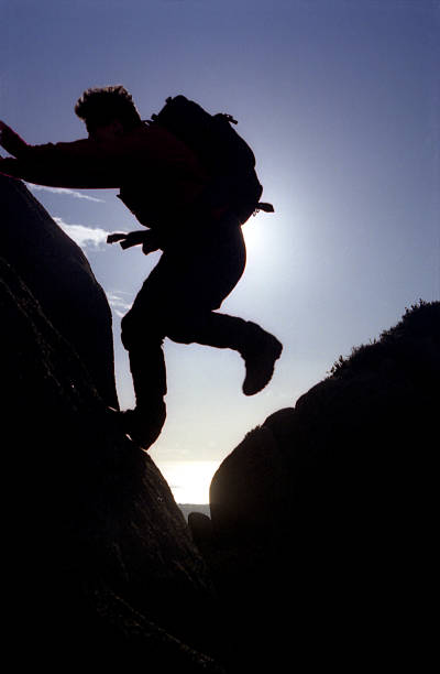 istock hiker jumping from rock to rock 139857601