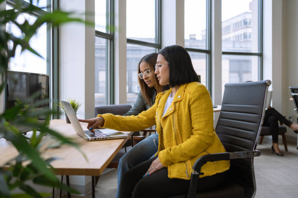 Woman mentoring a young employee in the office stock photo
