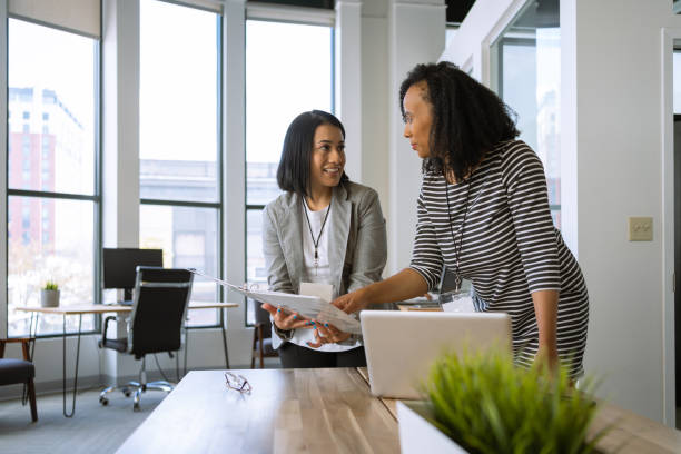 istock Woman interacting with a coworker at the office 1398578026