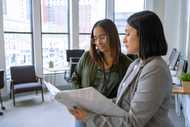 Woman interacting with a coworker at the office stock photo