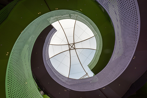 A spiral shaped color perforated metal staircase.This scene is located in the Sunshine Youth Activity Center, Putian City, Fujian, China