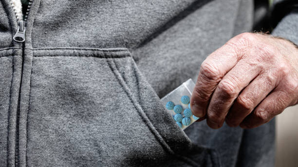 oxicodona de fentanilo opioide en bolsa de plástico en la mano sosteniendo por el bolsillo de la chaqueta - fentanyl fotografías e imágenes de stock