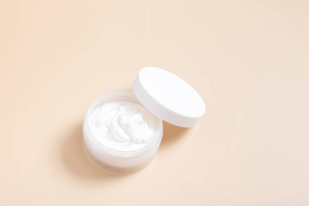 istock Plastic jar with white lid with cream on a beige background 1398584039