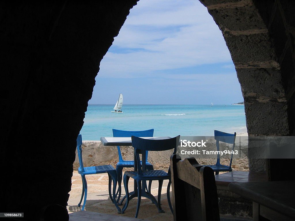 Seaside dining Distant sailboat viewed through an arch at a seaside restaurant in Varadero, Cuba. Arch - Architectural Feature Stock Photo