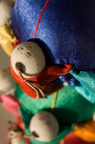 A little asian doll climbing a blue pin cushion
