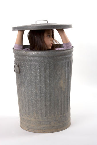 A Young Girl hiding in a garbage can