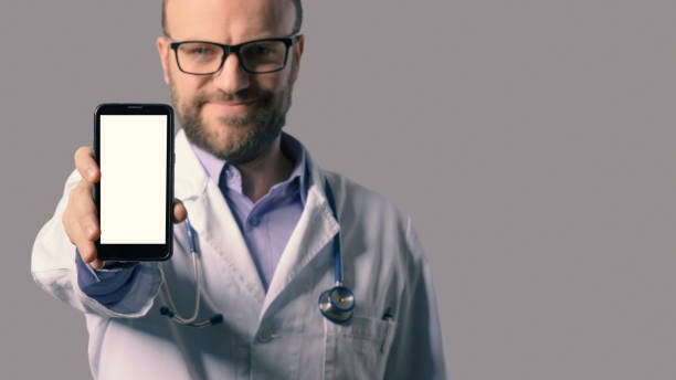 istock Smiling doctor showing a smartphone 1398594783