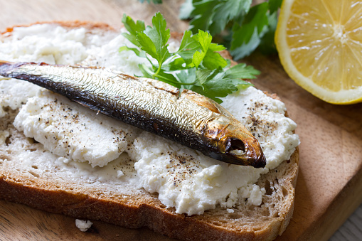 Sandwich with sprats, cottage cheese and parsley concept