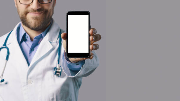 Smiling doctor showing a smartphone stock photo