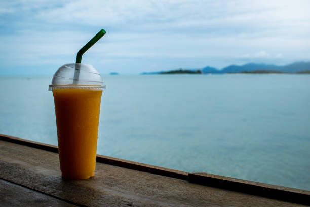 istock Mango smoothie on a bar table, overlooking the sea. 1398595662