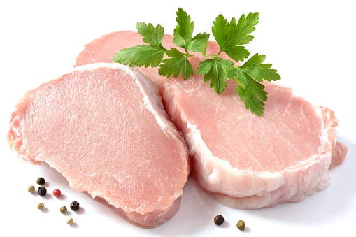 Smoked pork meat - gammon with herbs on rustic plate.  Isolated, white background. Top view