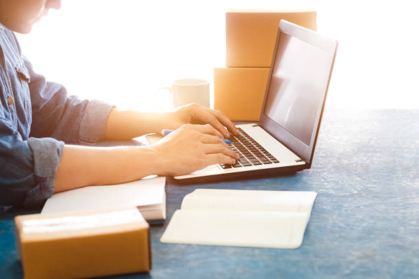 istock Young Asian men is accepting new orders from customers through laptops, business owner working at home office packaging on background, online shopping e-commerce or freelance working concept. 1398596595