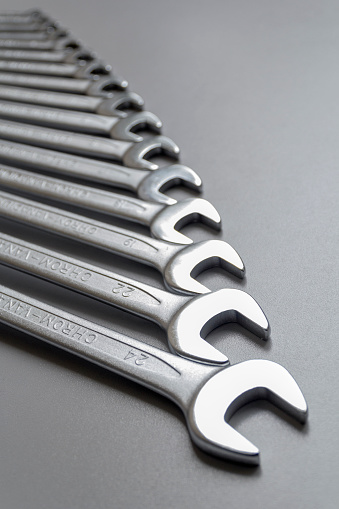 Spanners. Many wrenches. Grey background. Set of wrenches in different sizes on grey background. Top view with copy space.