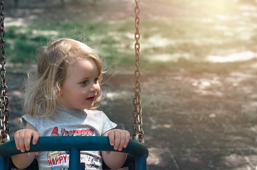 happy little girl plays in the playground