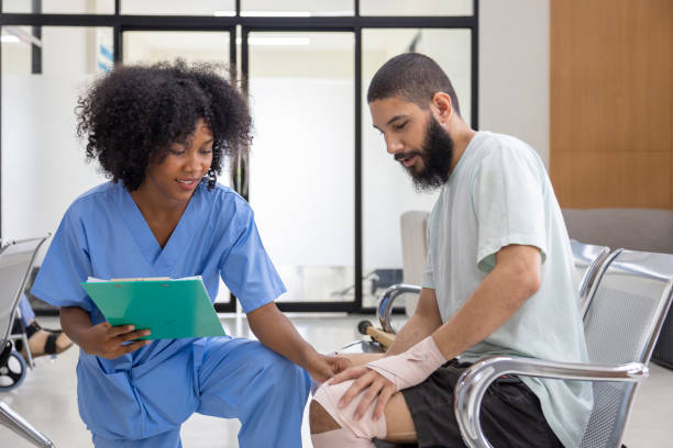 une infirmière africaine examine une tendinite sur une blessure au genou causée par un accident de sport chez un patient du moyen-orient pour un traitement et un processus de réadaptation - orthopedics photos et images de collection