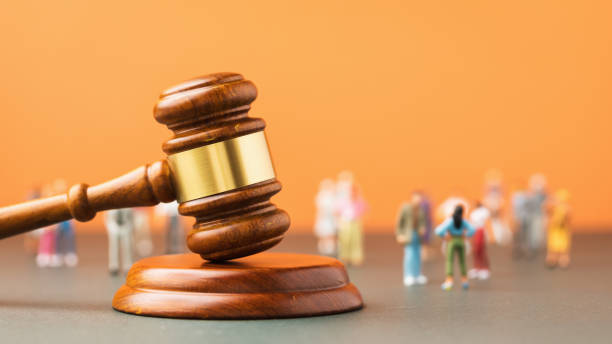 istock Judicial gavel and plastic toy men on a colored background, a concept on the topic of litigation in society 1398601866