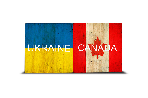 Flags of Ukraine and Canada on wooden blocks. Isolated on white background. Commonwealth. Support. Cooperation. Politics. Economy.
