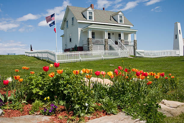 Lighthouse Keepers House-Pemaquid Point ME View of lighthouse keepers cottage with tulip bed in foreground. lighthouse maine new england coastline stock pictures, royalty-free photos & images