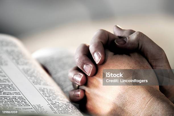Praying Hands Over A Holy Bible Stock Photo - Download Image Now - Individuality, Religion, Adult