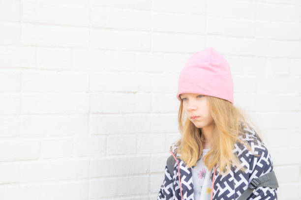 sad girl at the white brick wall. empty space for text