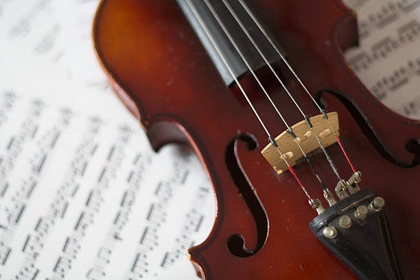 Violin angle violin placed on sheet music. violin f hole stock pictures, royalty-free photos & images