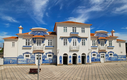 Historic building of old Aveiro Railway station ornamented with typical blue azulejos tile exterior, which tells a story of life in traditional Portugal. Aveiro, Portugal.