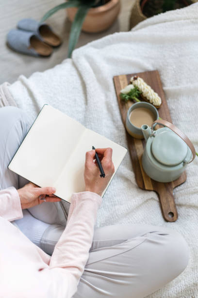 istock Female hands hold pen and personal diary with blank pages 1398617480