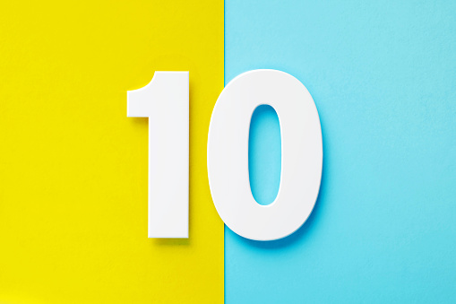 Extruded white number 10 sitting over yellow and blue background. Horizontal composition with copy space.