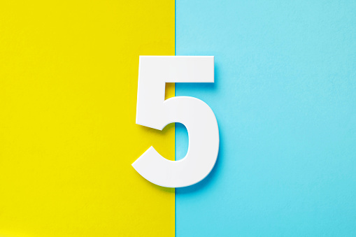 Extruded white number 5 sitting over yellow and blue background. Horizontal composition with copy space.