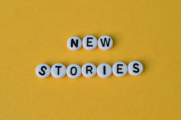 istock Alphabet beads with text NEW STORIES isolated on a yellow background 1398620610