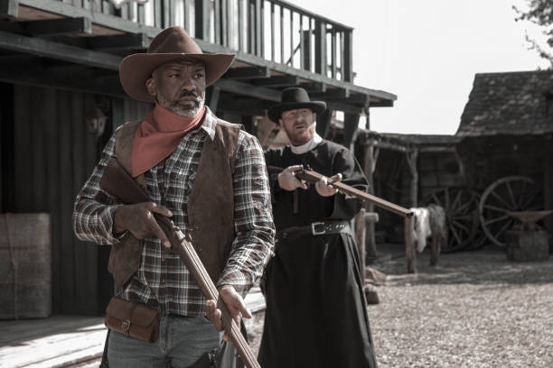 istock Handsome Black Cowboy with a priest in an authentic wild west setting 1398621566