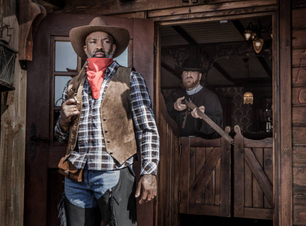 istock Handsome Black Cowboy with a priest in an authentic wild west setting 1398622673
