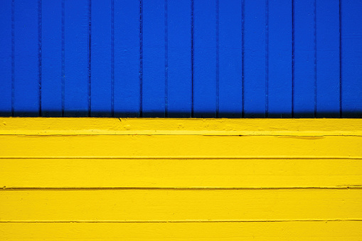 Like Ukrainian flag. Wooden paneling of the house. Bright blue and yellow colors