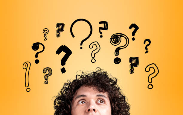 istock Businessman with inspired look, eyes up, set of question marks 1398624331