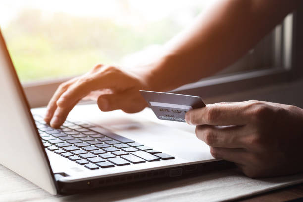 istock Businessman hand holding credit card with using laptop for online shopping while making orders at home. business, lifestyle, technology, ecommerce, digital banking and online payment concept. 1398629041