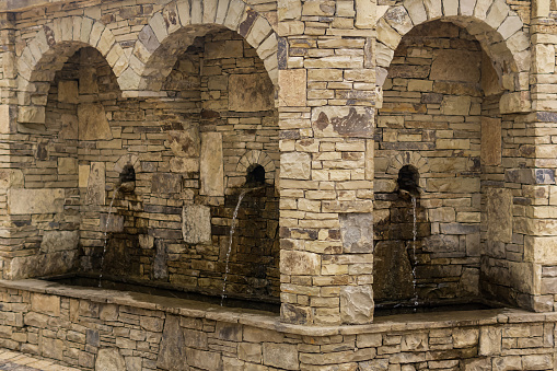 street drinking fountain in a natural stone arch