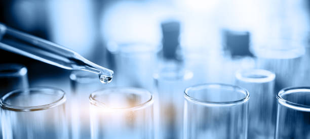 Laboratory research, dropping liquid to test tube. Test tube containing chemical liquid in laboratory stock photo