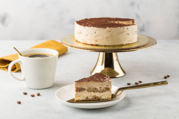 tiramisu cake on a golden cake stand. light background - cake chocolate cake chocolate gateaux imagens e fotografias de stock