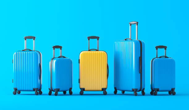Yellow suitcase standing in terminal, full of blue suitcases stock photo