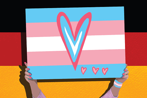 Transsexual woman with trans flag, holding a transgender pride flag