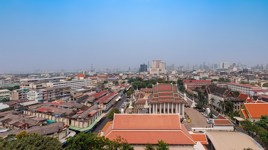 Bangkok, Thailand-April 9, 2022: Top View of Golden Mountain or Wat Saket Temple, A famous landmark in Bangkok with Modern skyscrapers and buildings in the background.