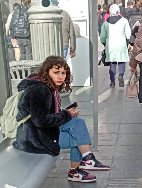 Young woman looking lost, waiting for the bus at Jerusalem Central Station.